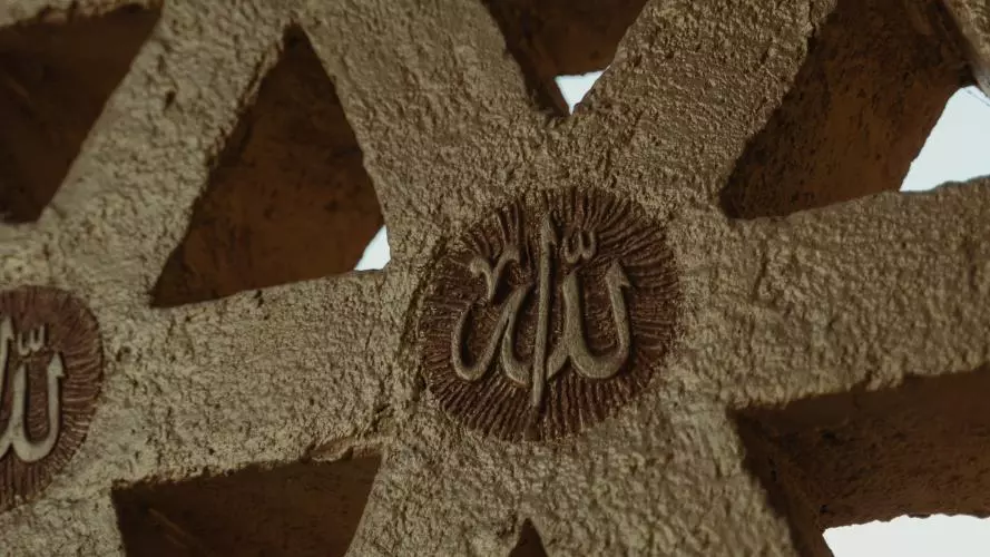 Picture of a concrete, geometric wall with the word "Allah" in Arabic